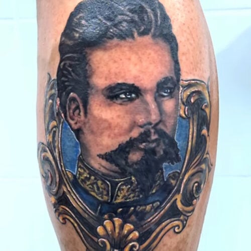 Tattoo wade mit maenner gesicht und gold rahmen